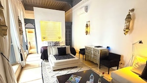 A living room with a sofa, a coffee table, and a patterned rug. - Riad Adore (Marrakech)