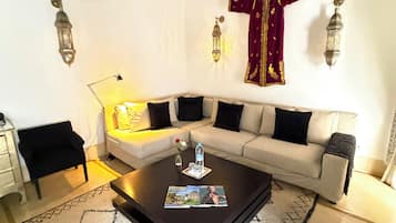 A living room with a sofa, coffee table, and decorative wall sconces.