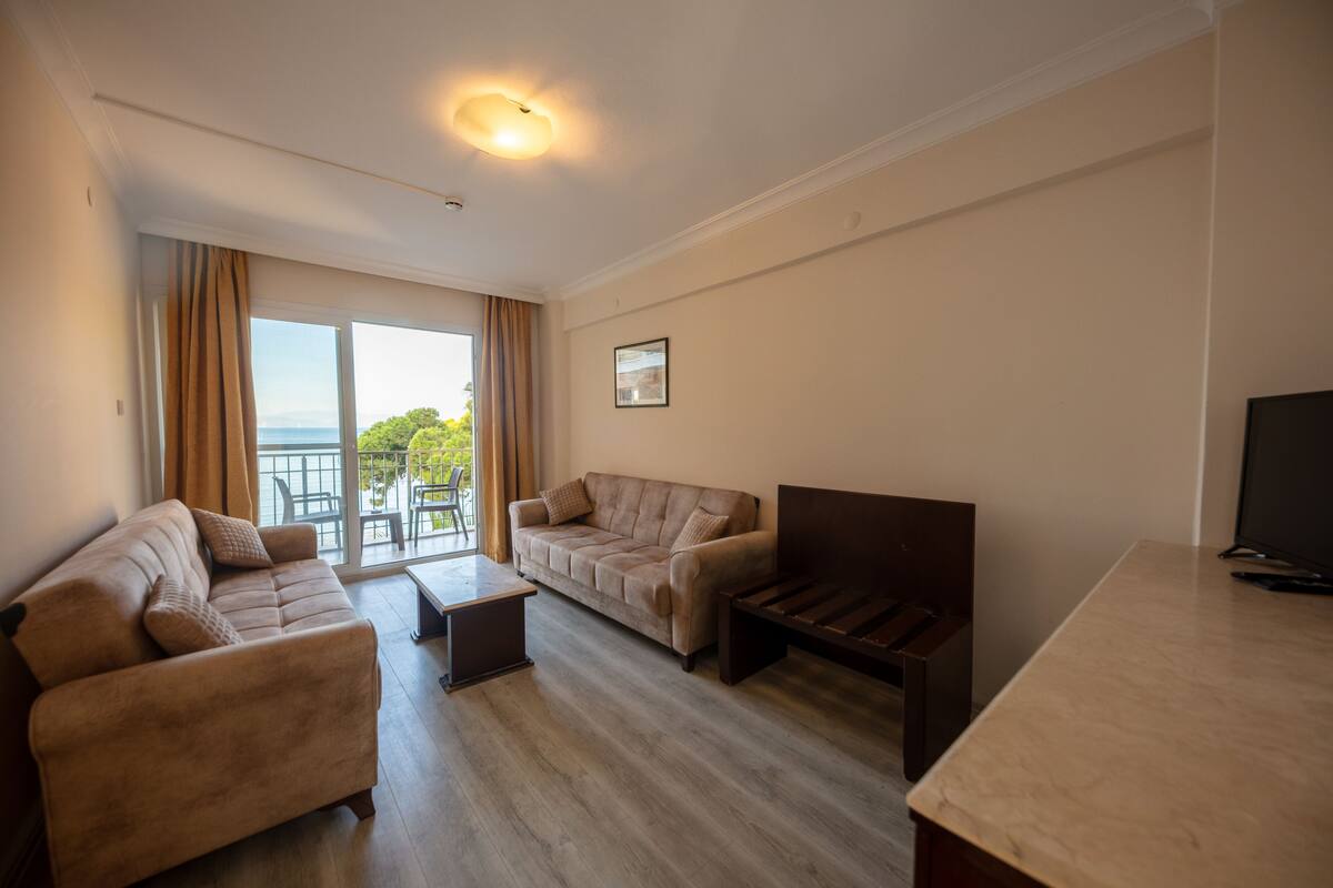 Amplia sala de estar con un conjunto de sofás, una mesa de centro y un mueble para televisión.