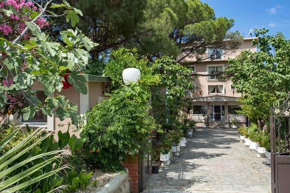 A stone pathway leading to a building with a sign reading "MELIS." - Melis Otel (Kusadasi)