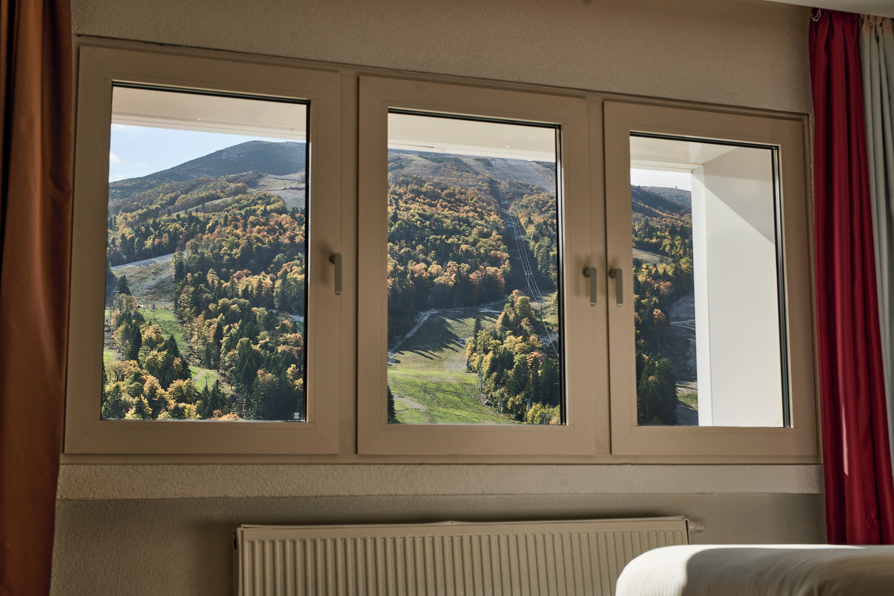 Une pièce dotée d’une grande fenêtre donnant sur un paysage montagneux.