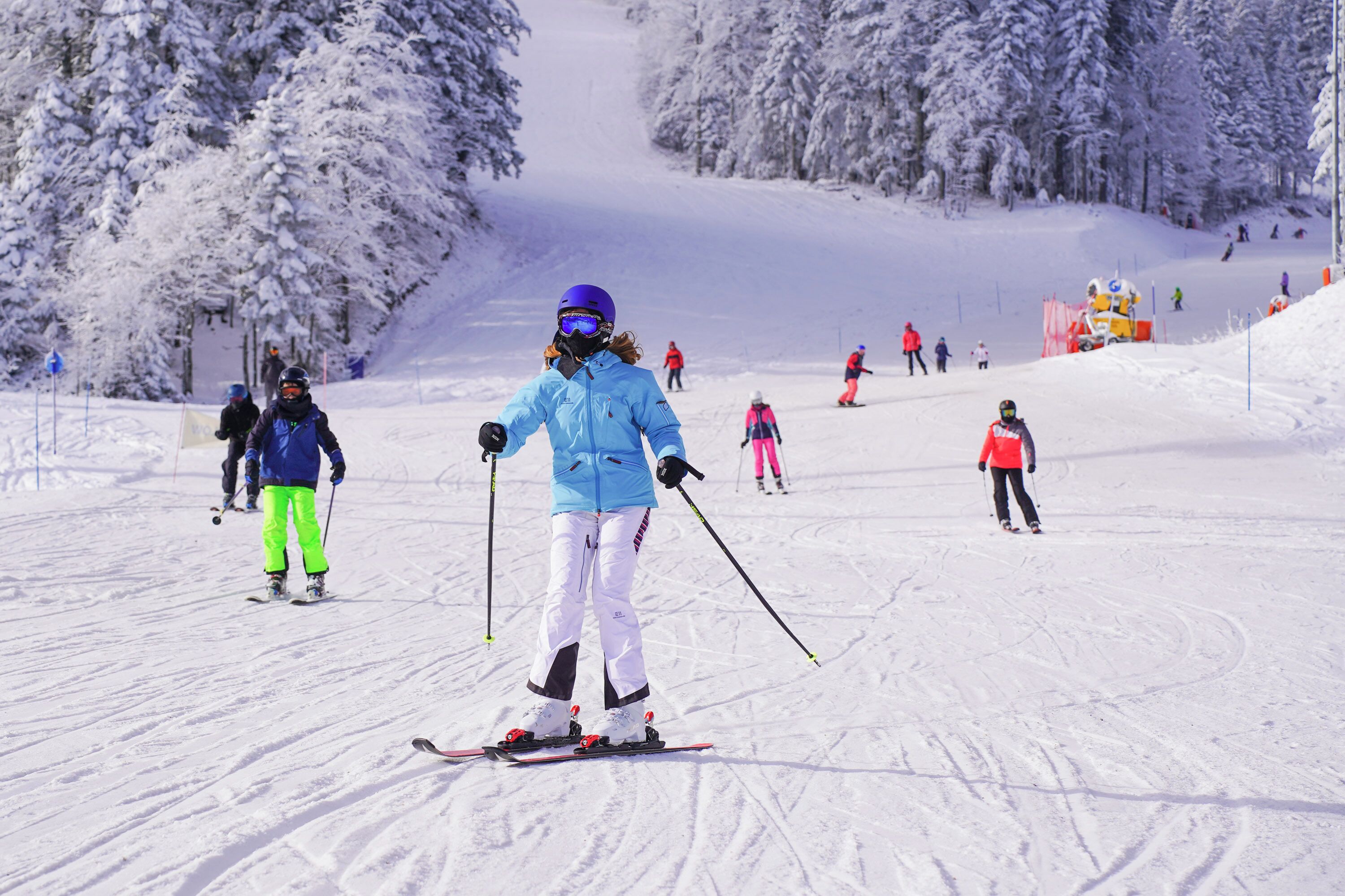 A ski slope with skiers in various outfits.