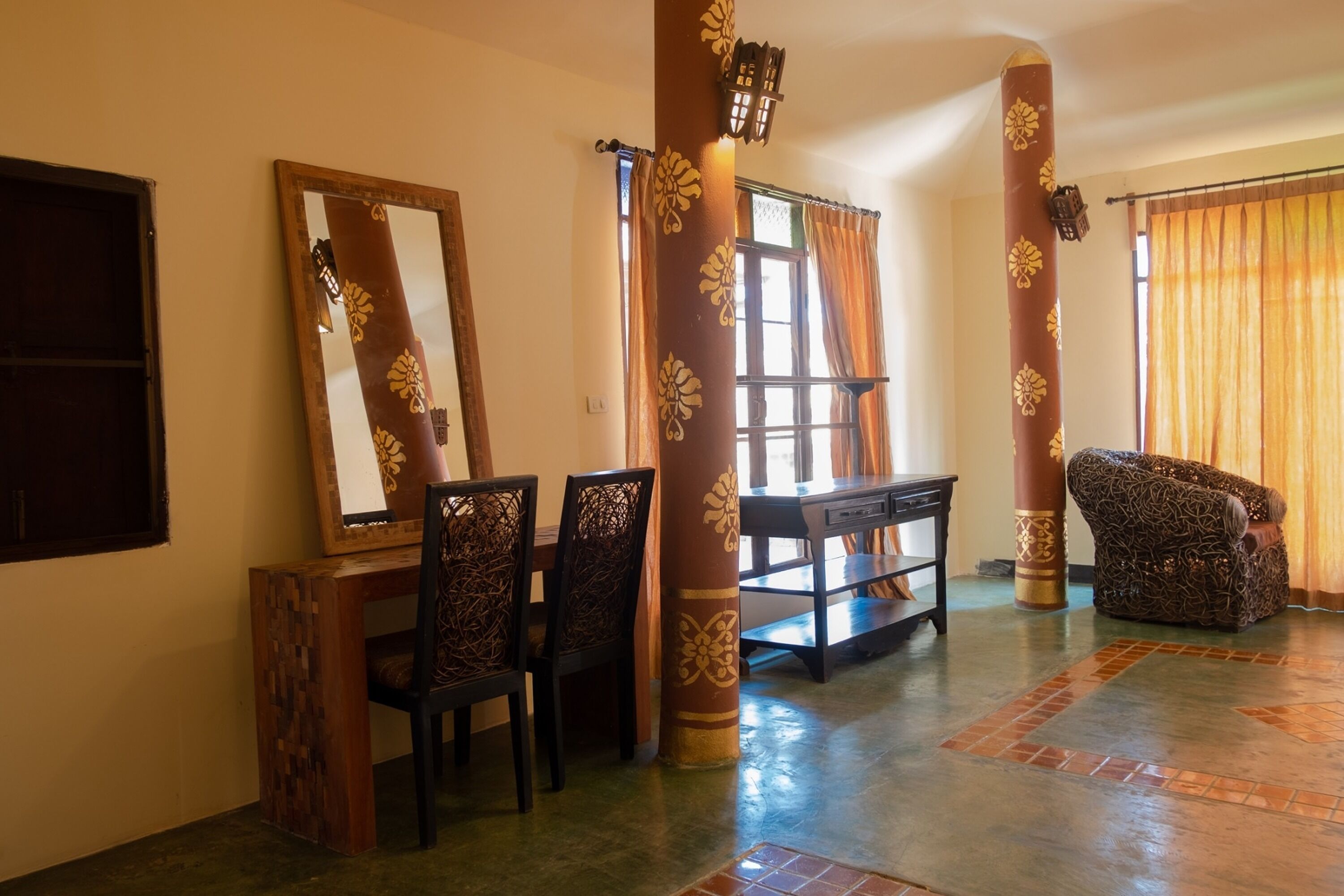 A room with a dining table, chairs, a sofa, and a large mirror.