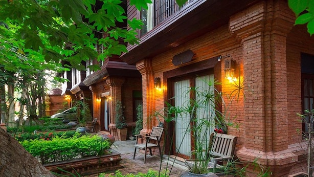 A traditional brick building with a courtyard. There are benches and potted plants. - Baan Tawai Lanna Resort (Hang Dong)