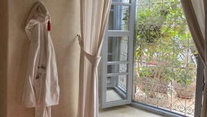 Una habitación con ventana, cortinas y una toalla colgada en la pared.