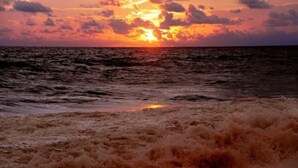 A sunset over the ocean with waves crashing onto the shore. - Arcade Beach Hotel (Induruwa)