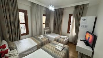 Habitación triple estándar | Ropa de cama de alta calidad, caja fuerte, escritorio y cortinas opacas