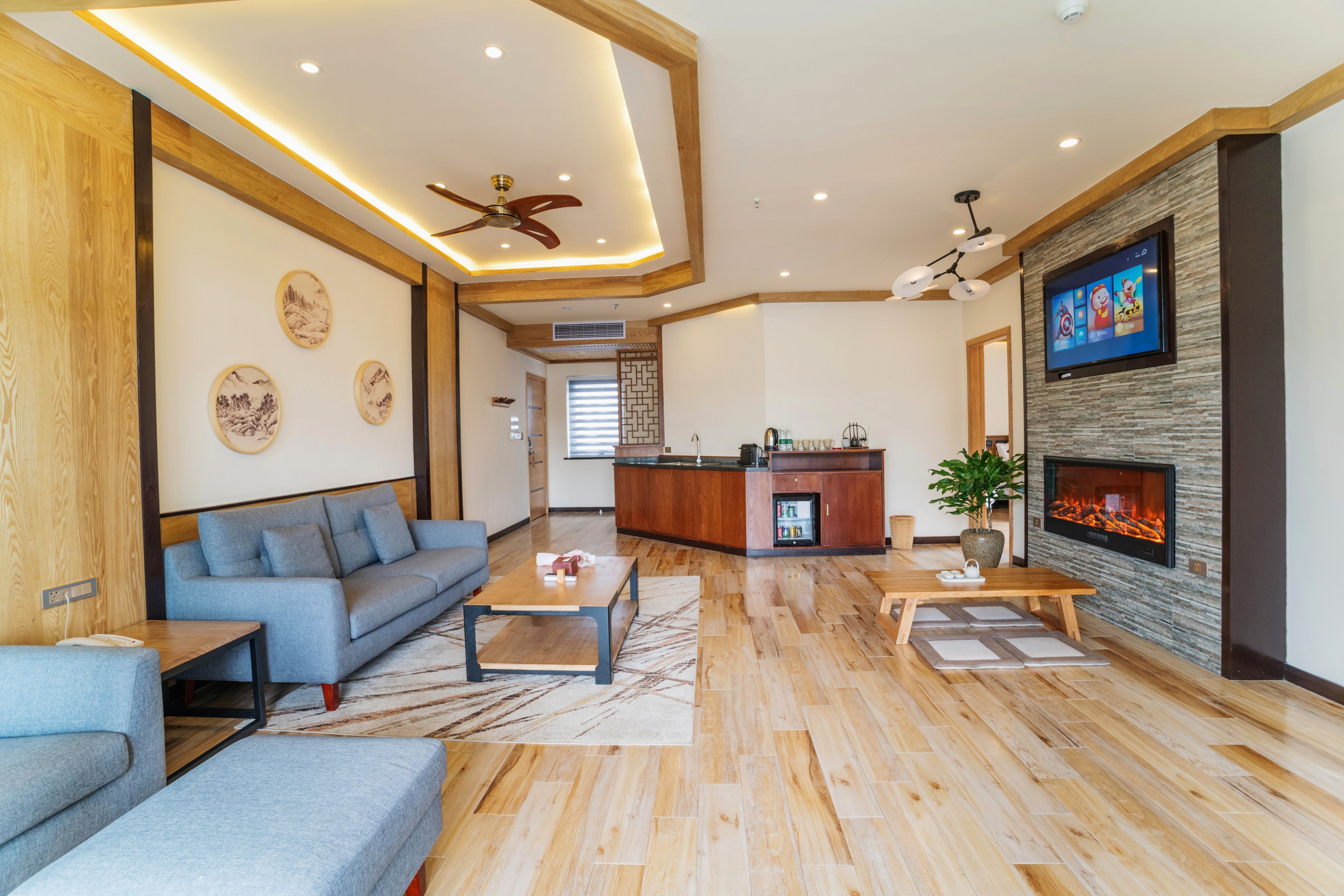 A modern living room with a sofa, coffee table, and fireplace.