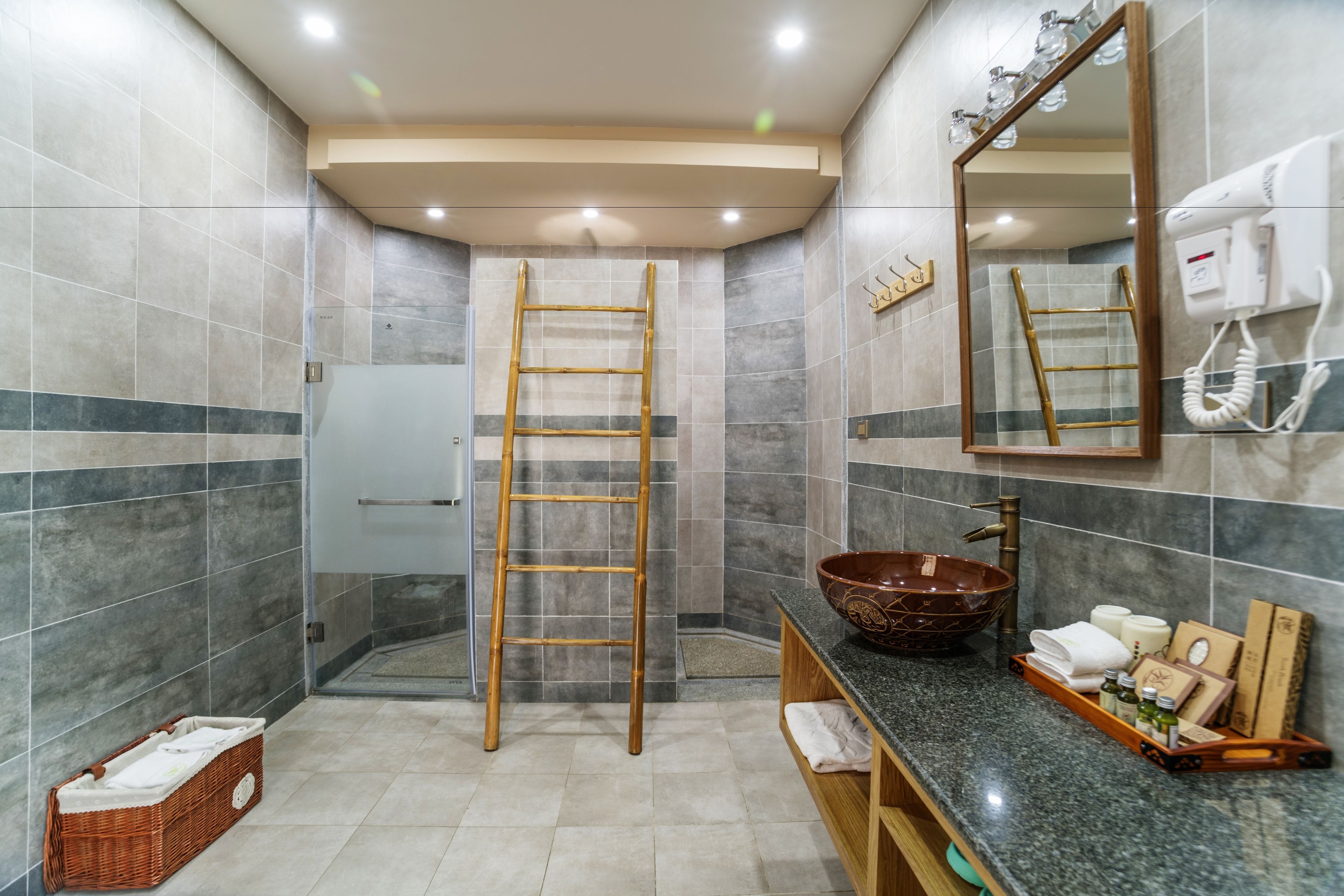 Une salle de bain moderne avec un grand miroir, une échelle en bois, un lavabo sur colonne et un porte-serviettes.