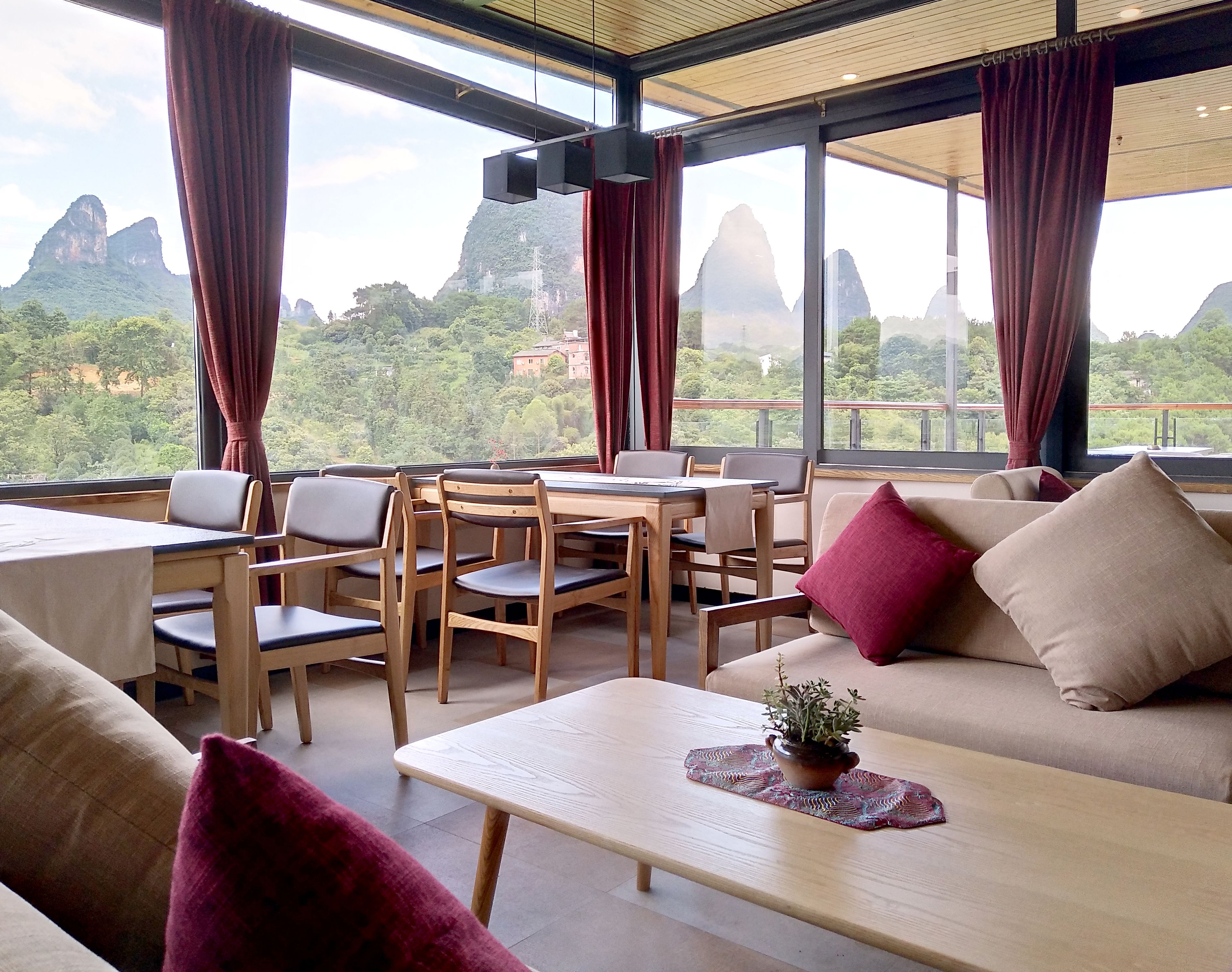 Una habitación con comedor, un sofá y vistas a las montañas.
