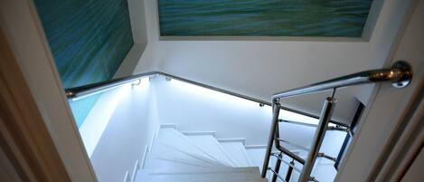A staircase with a metal handrail and white steps leading to a landing.