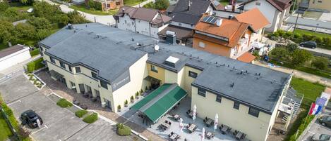 Un edificio a più piani con tetto piatto, un parcheggio e un ristorante al piano terra.