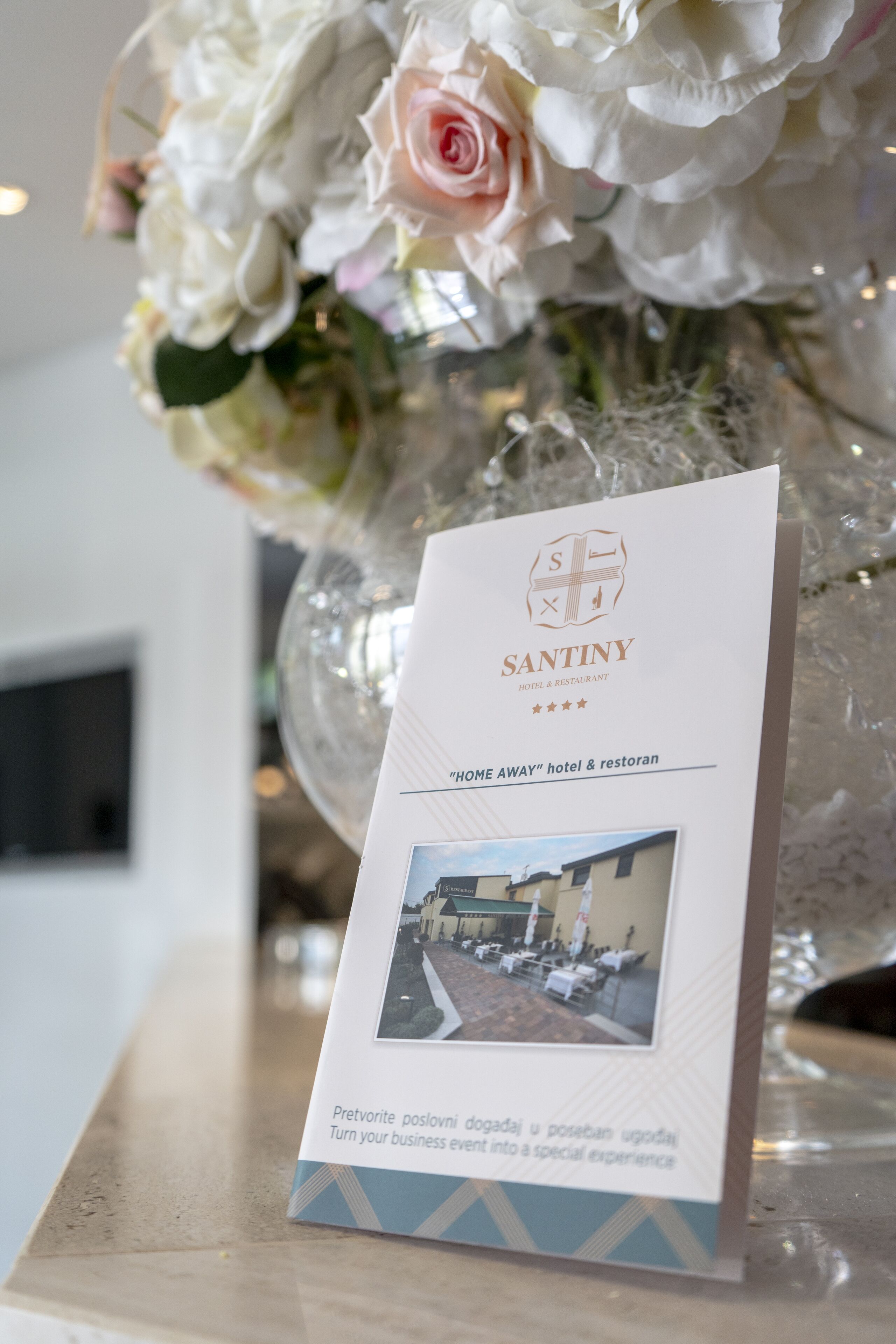 Eine Broschüre für das Santiny Hotel & Restaurant mit dem Slogan "HOME AWAY", ein Bild des Hotels und eine Beschreibung des Erlebnisses.