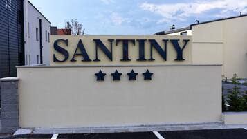 A sign with the word "SANTINY" and four stars, indicating a hotel or property name and its rating.