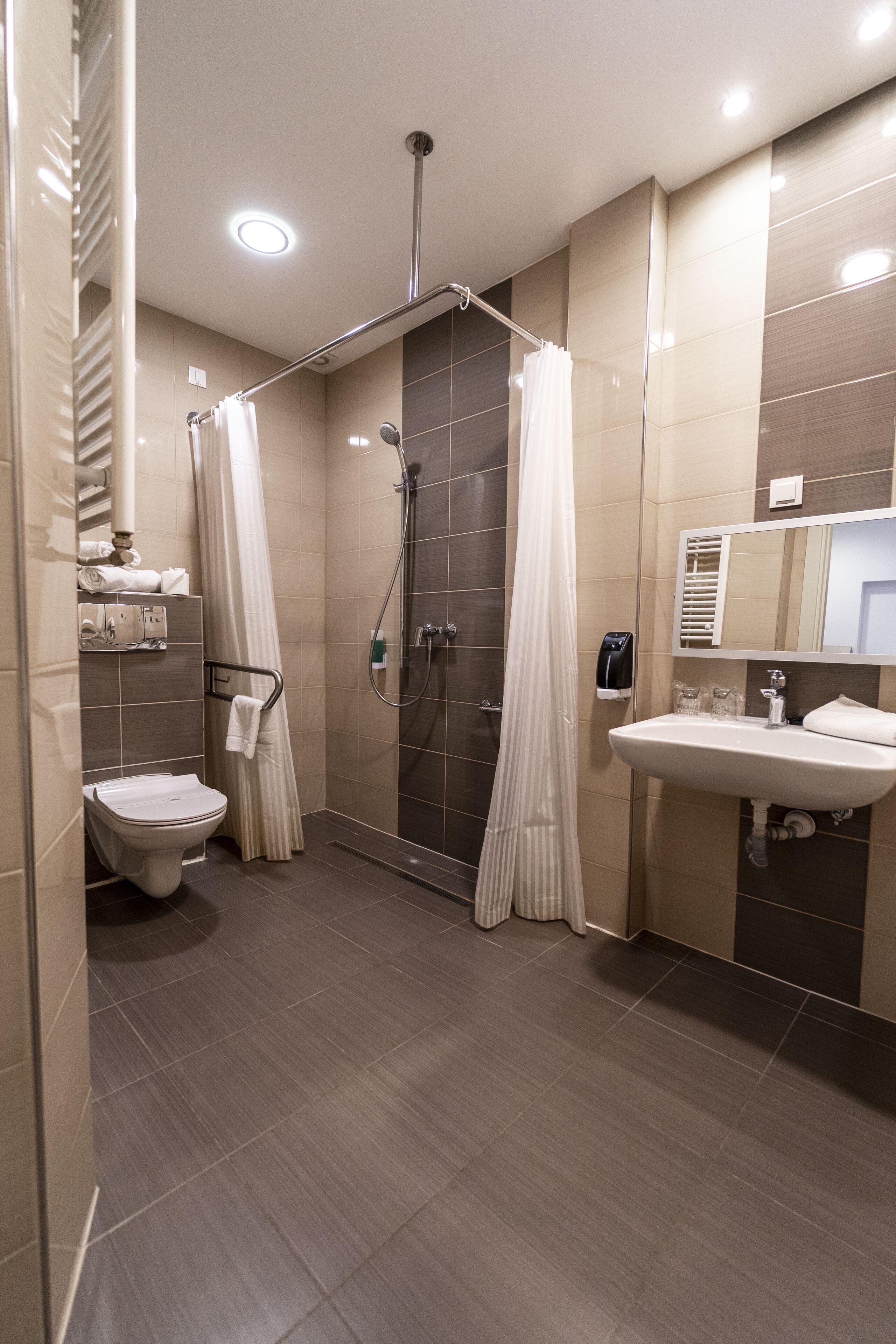 A modern bathroom with a shower, toilet, and sink.