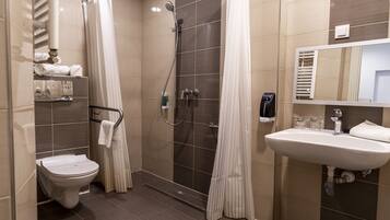 Un baño moderno con ducha, inodoro y lavamanos.
