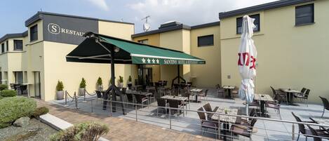 Un Hotel & Restaurante Santiny con terraza al aire libre y un patio cubierto.