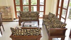 A room with a sofa set, a coffee table, and a wicker basket. - Araliya Blue Beach View Hotel (Negombo)