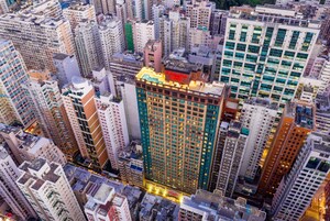 Un edificio alto con varios pisos, que destaca por un letrero de hotel en la parte superior.