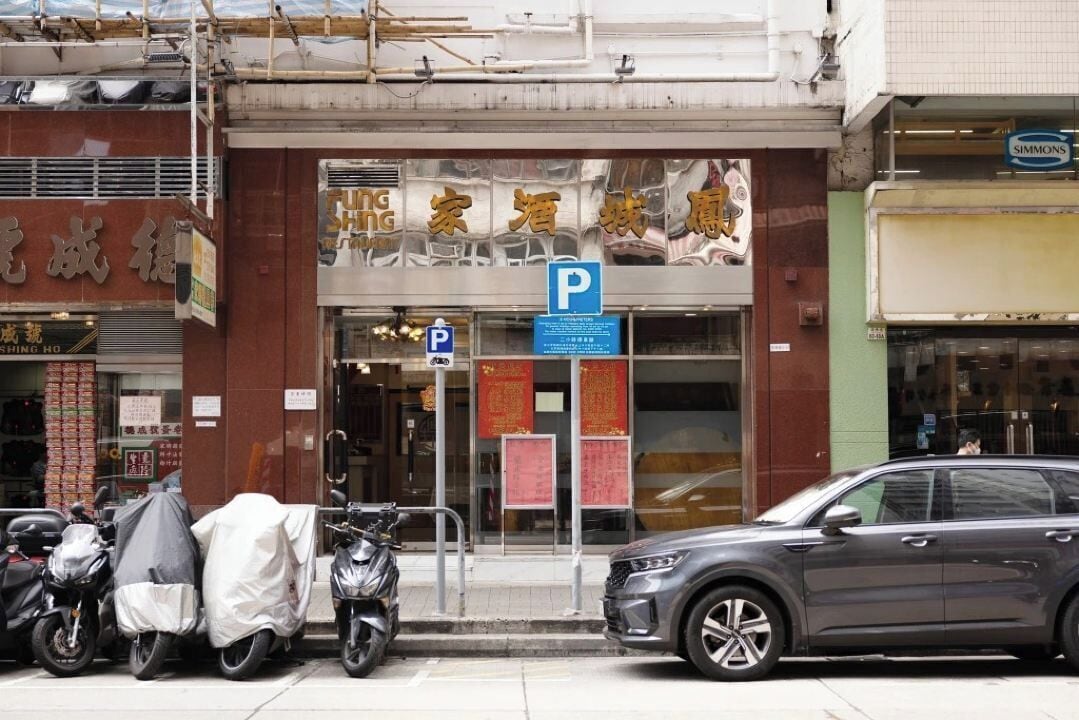 A building with a storefront and a parking sign.