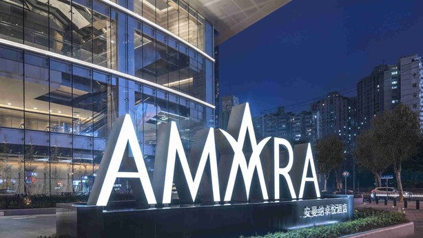 A modern building with a large illuminated sign reading "AMMARA".