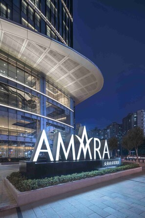 A modern building with a large illuminated sign reading "AMMARA". - Amara Shanghai (Shanghai)
