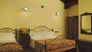 Een kamer met twee bedden, een houten garderobe en een spiegel aan de wand.