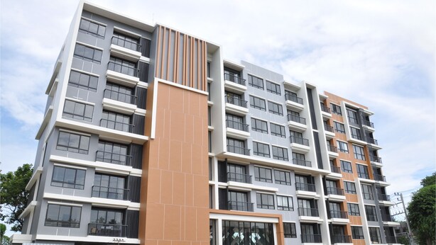 Um edifício residencial de vários andares com varandas, janelas amplas e design arquitetônico moderno.