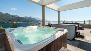 Een jacuzzi met uitzicht op bergen, zitplaatsen buiten en een heldere lucht.