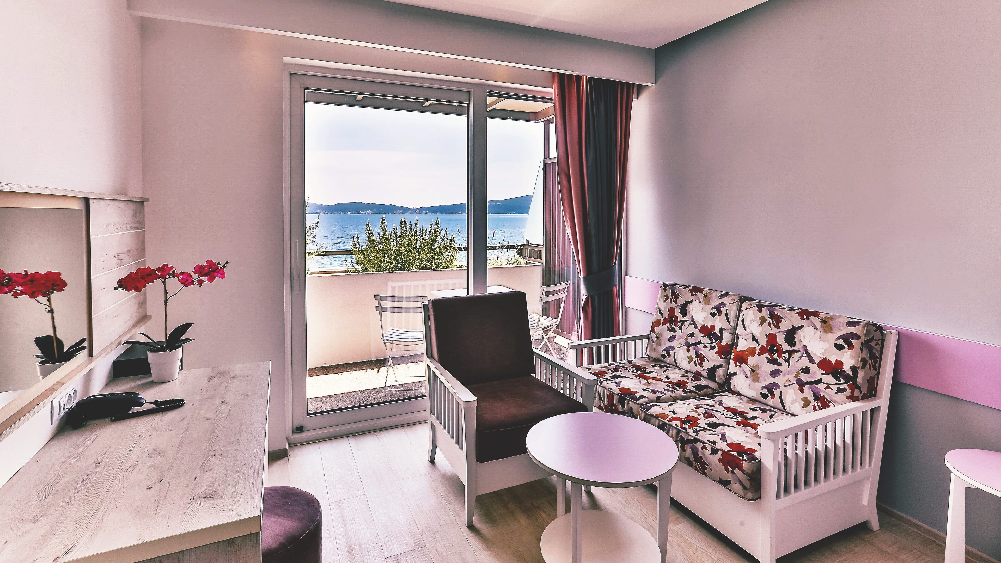 A balcony with a sofa, a chair, and a small table.
