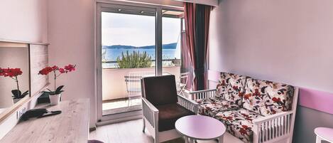 A balcony with a sofa, a chair, and a small table.
