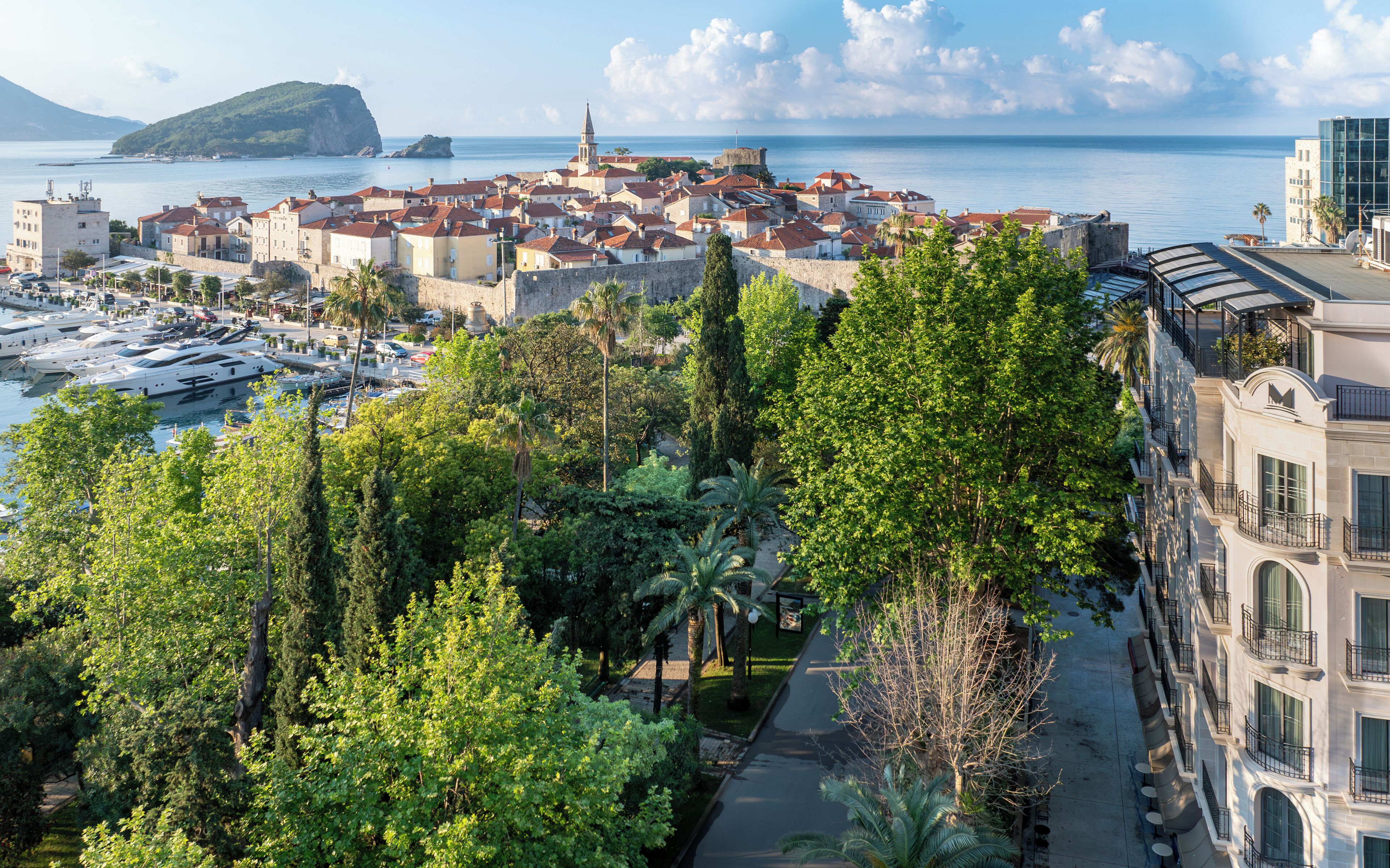 A coastal town with historic buildings, a marina, and a prominent church.
