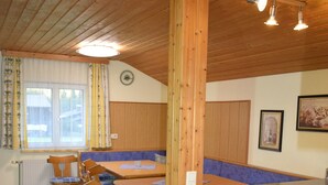 Un interior de madera con comedor, banco y mostrador de cocina.