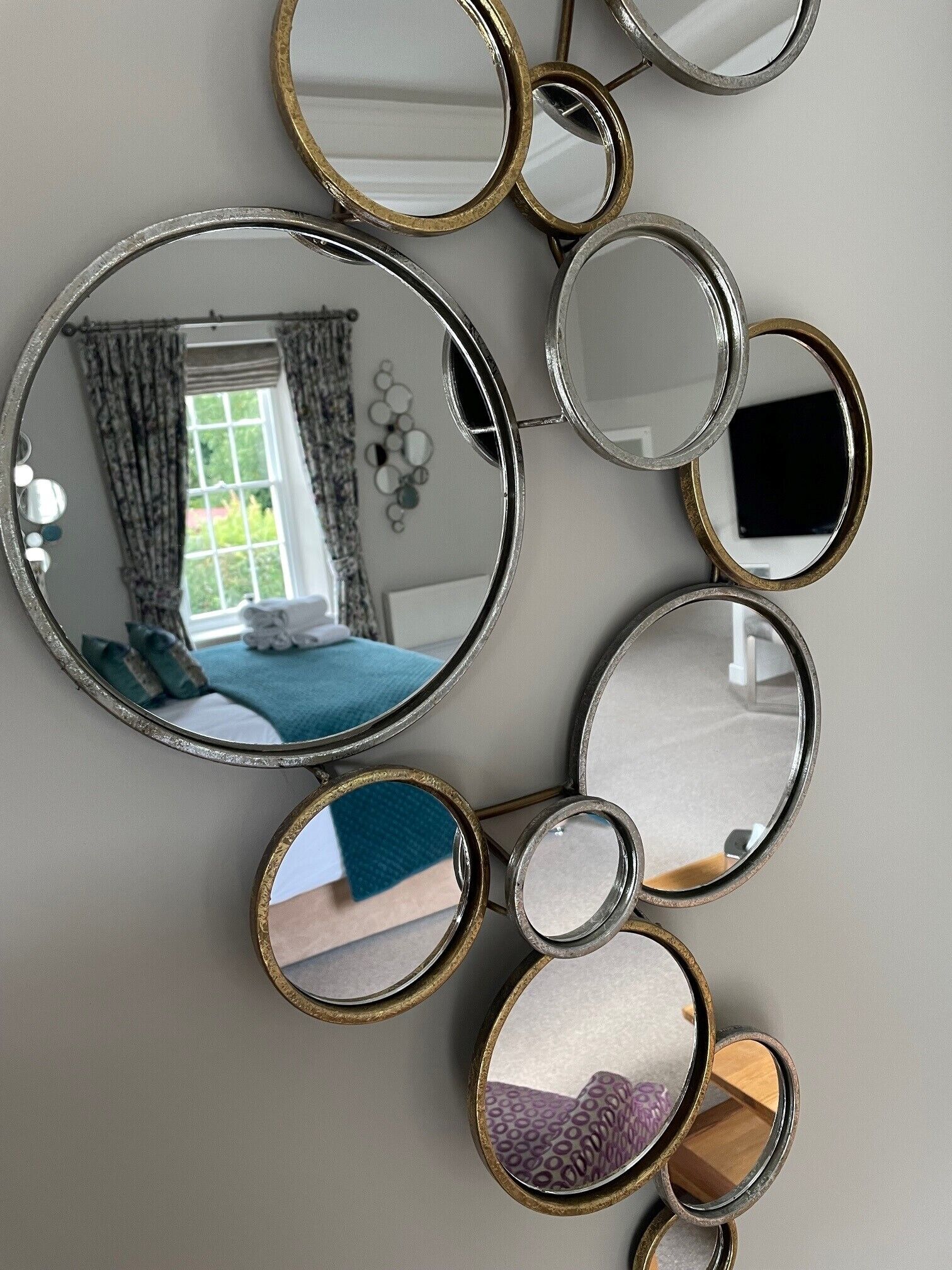 A wall-mounted mirror with multiple circular frames.