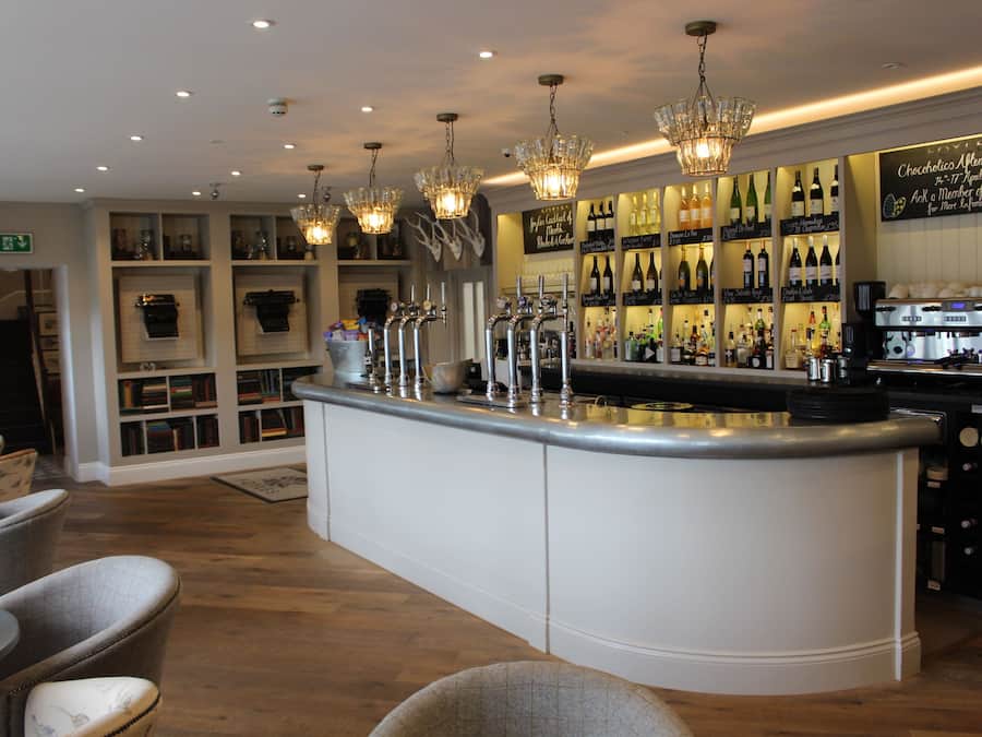 A bar area with a central counter, multiple taps, and a wine display.