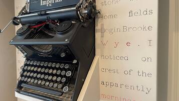 An antique Imperial typewriter on display with a backdrop of printed text.