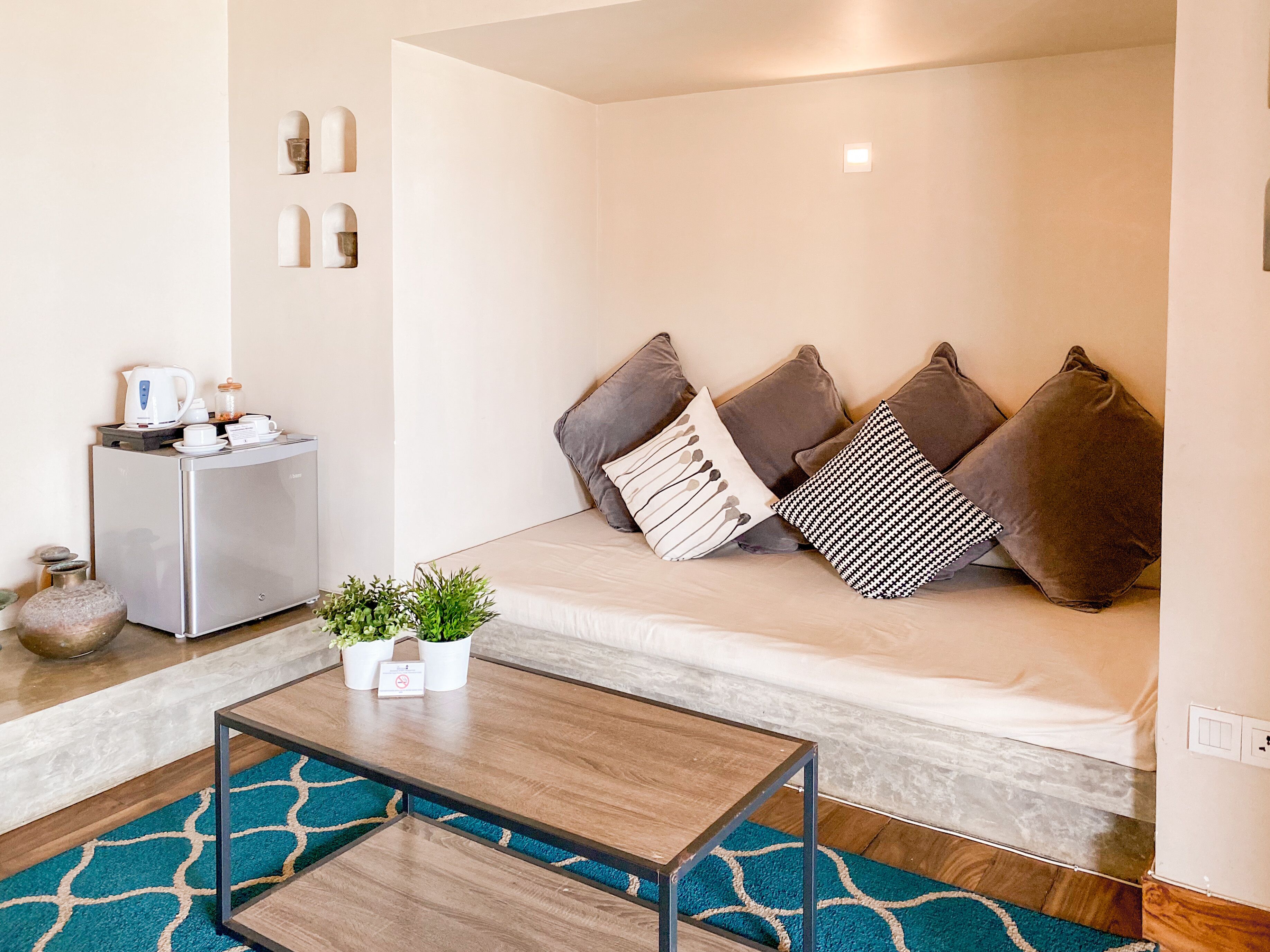 Una sala moderna con sofá, mesa de centro y una pequeña cocina.