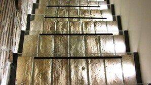 A staircase with a textured wall on one side and a plain wall on the other. - The Right Place 4U Roma Navona Terrace Luxury Rooms (Rome)