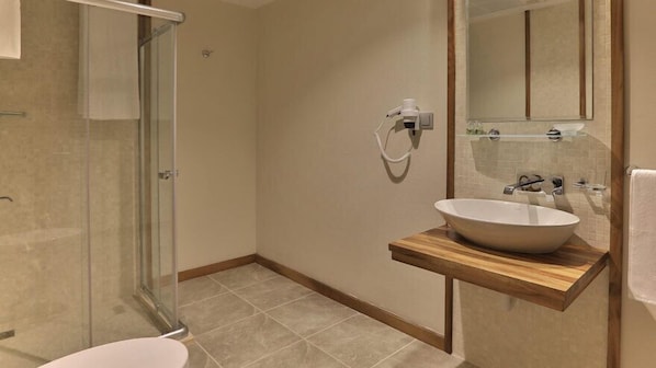 A modern bathroom with a glass shower enclosure, a wooden vanity with a large sink, and a mirror above the sink. - Kaçkar Resort Hotel (Camlihemsin)