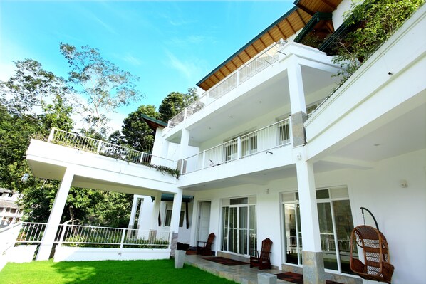 Un bâtiment à deux étages doté d’un patio couvert, de grandes fenêtres et d’un balcon avec des balustrades.