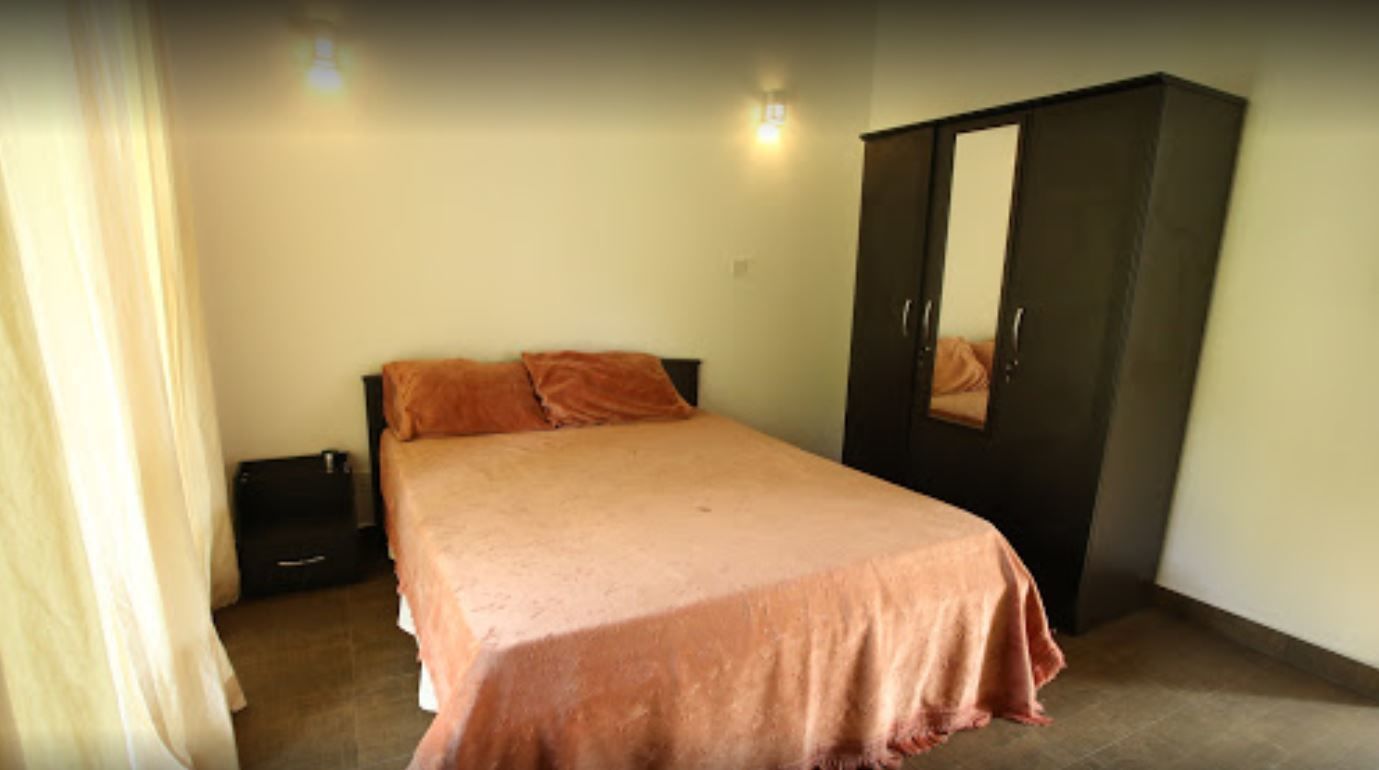 A bedroom with a bed, a wardrobe, and a nightstand.