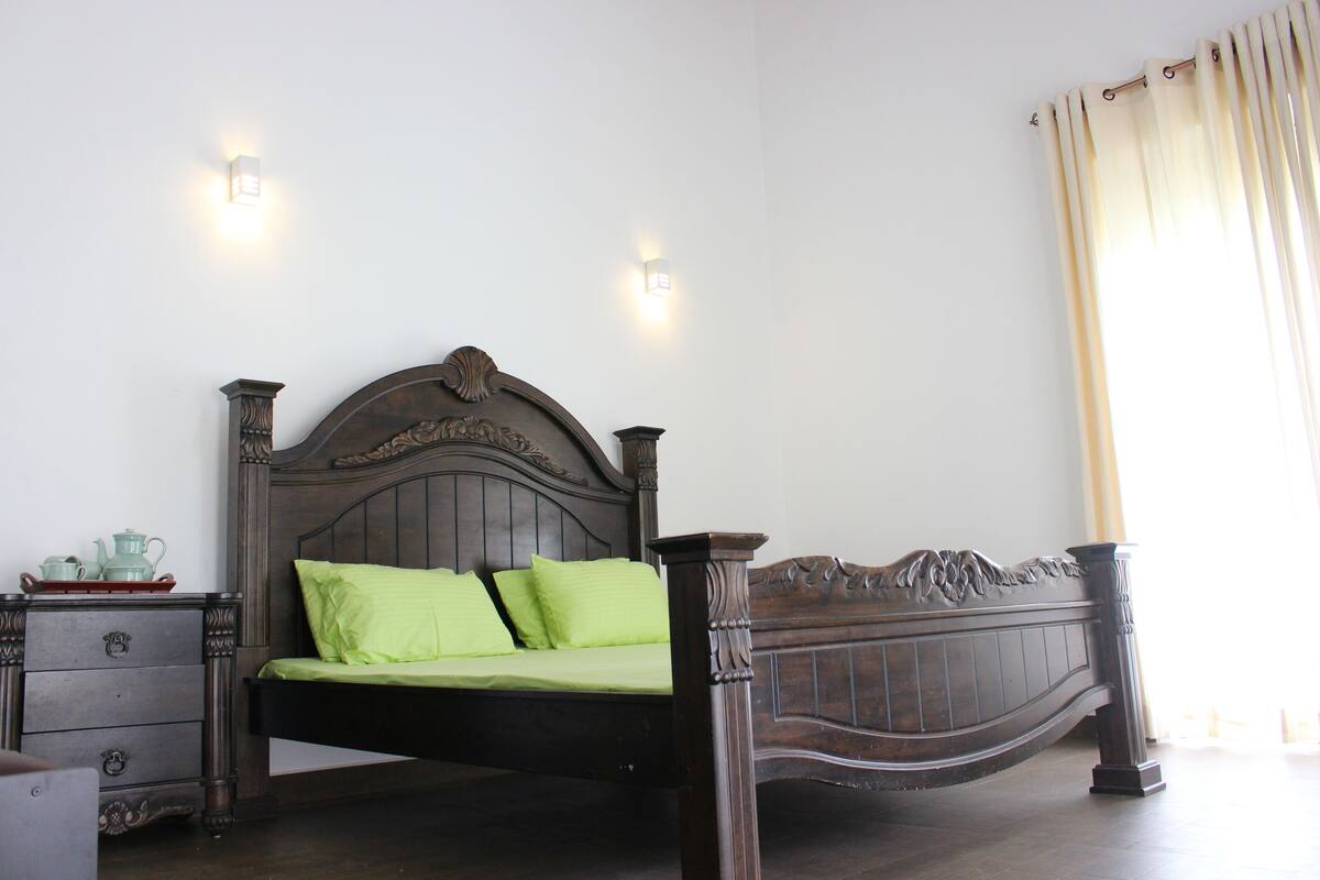 A bedroom with a wooden bed, two bedside tables, and a nightstand.