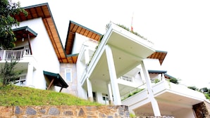 A modern building with a stone base, white walls, and wooden accents. - Sunlit Villa (Harispattuwa)
