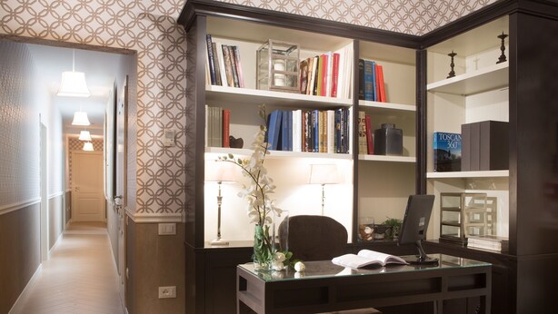 A study area with a desk, chair, bookshelf, and a lamp. - San Giuliano Inn - Adults Only (Florence)