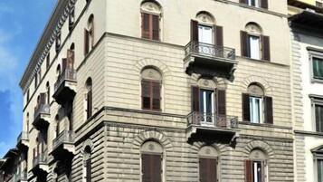Un edificio de varios pisos con estilo arquitectónico clásico, con ventanas en arco y balcones.