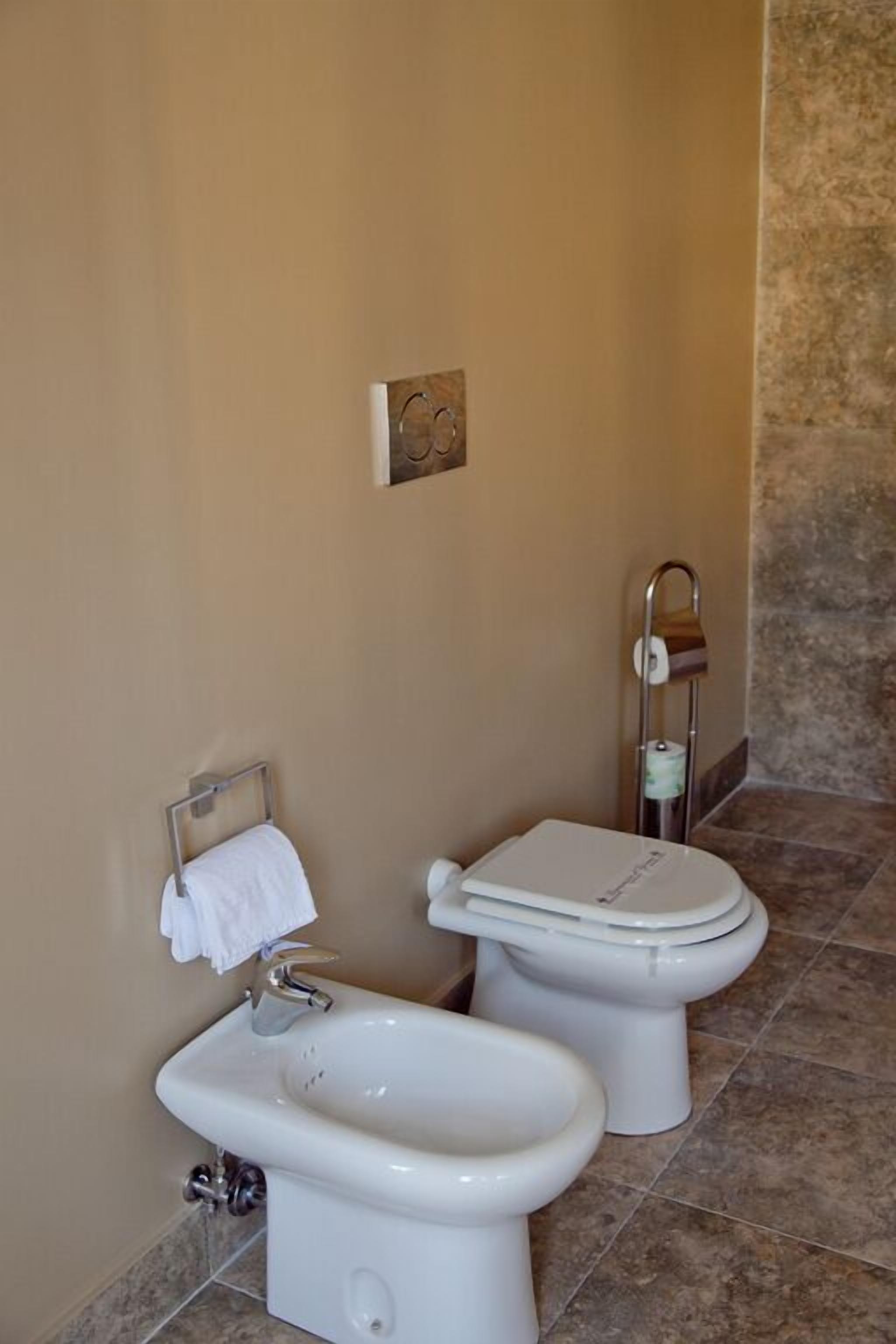 Un bagno con bidet, toilette e portasciugamani.