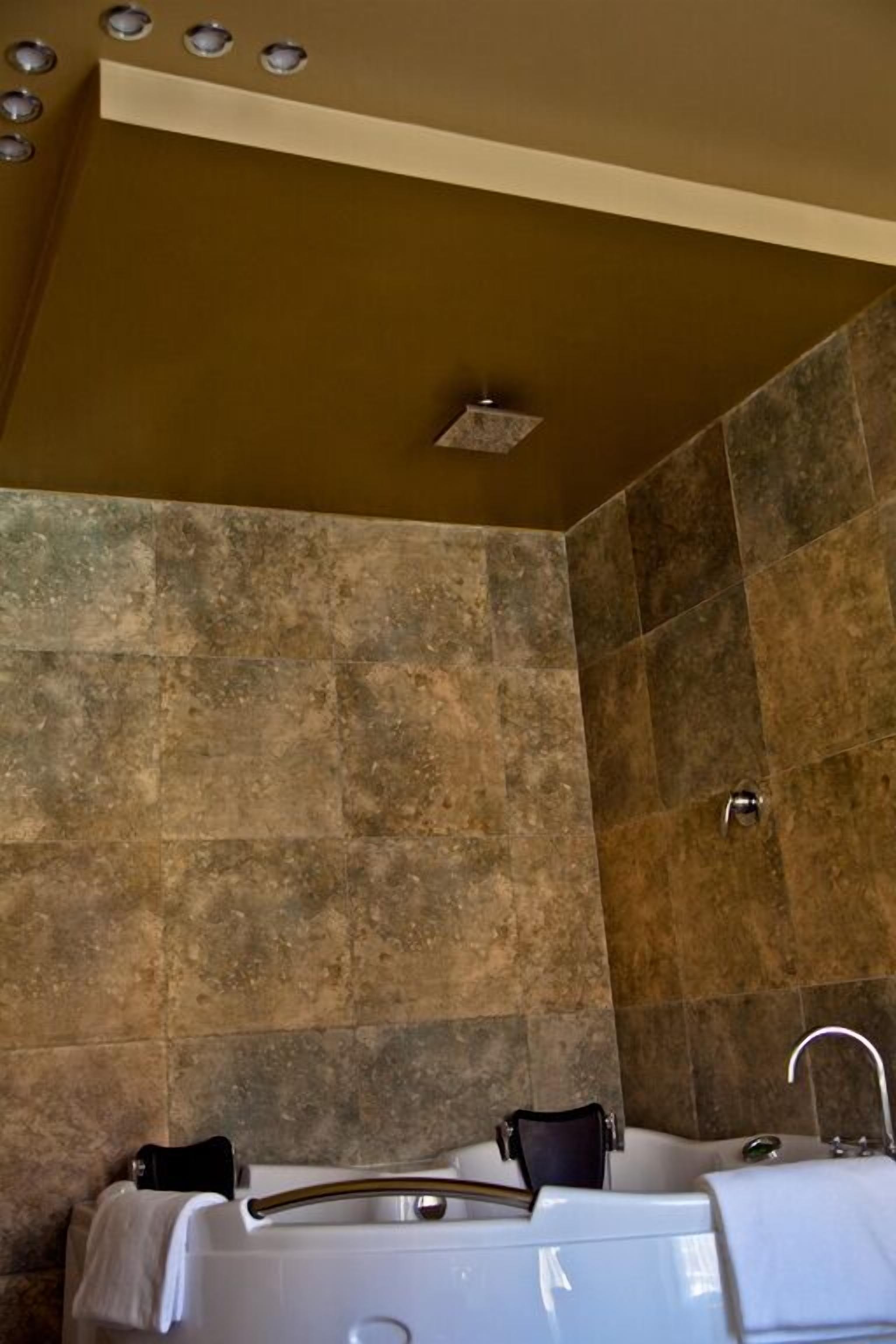 Une salle de bain avec une baignoire, une douche et un lavabo.