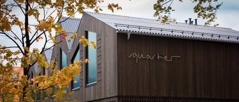 En moderne bygning med træfacade og metal tag, med teksten "quartier".