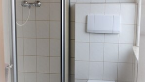 A bathroom with a glass shower enclosure, a toilet, and a towel rack. - Gasthof Stern (Burgsinn)