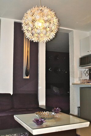 A modern living room with a glass coffee table, a decorative bowl, and a unique spherical light fixture. - Business Suites SG (Mexico City)